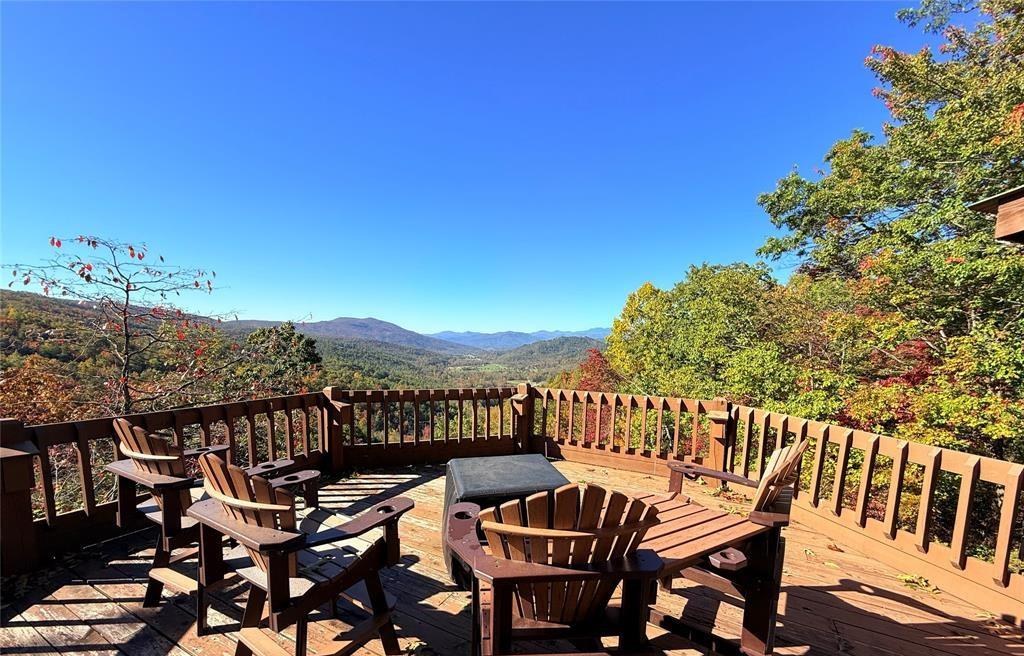A long table and Adirondack chairs on the open deck above the valley